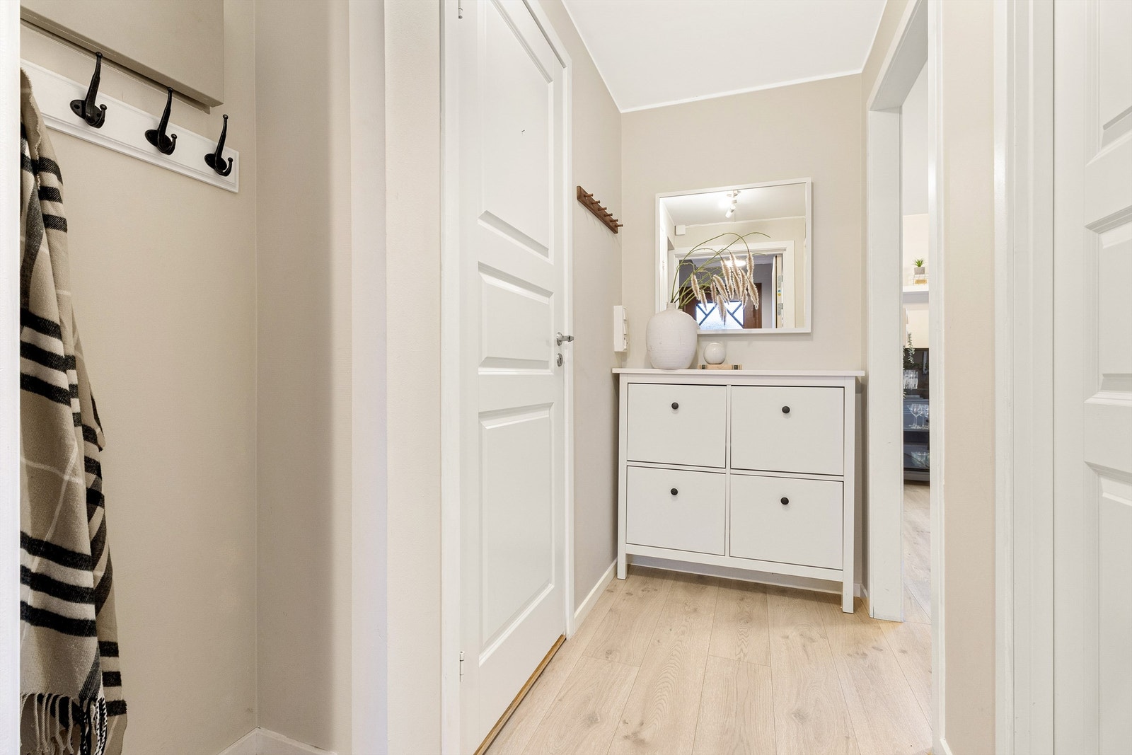 Lys og nymalt gang med smart innhukk i vegg for sko og jakker ved inngangspartiet. Galleribilde