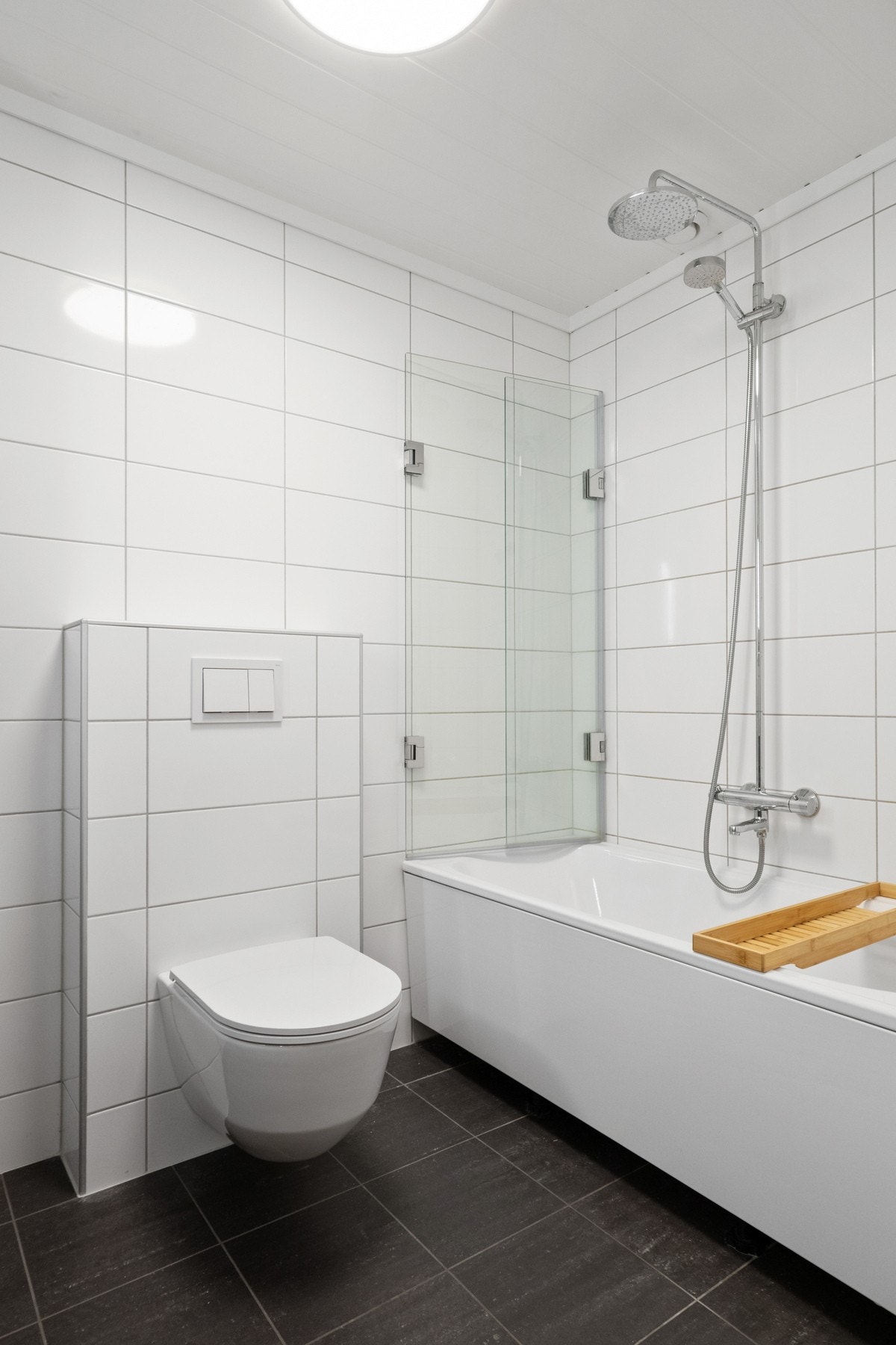 Badekar med regnfallsdusj og glassvegg gir både komfort og praktisk bruk i hverdagen. Galleribilde