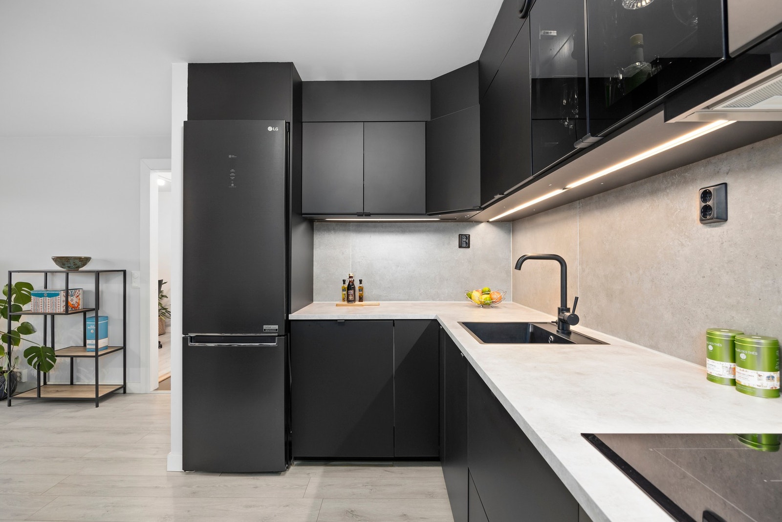 Innredning med mørke glatte fronter, laminat benkeplate, underlimt vask, fliser mellom benk og overskap, belysning og stikkontakter. Galleribilde