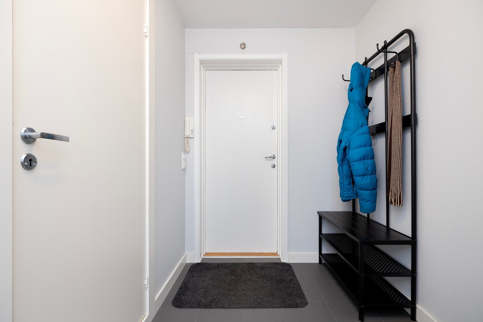 Velkommen inn! Entré med gulvfliser i grått og fin plass til ytterklær og sko. Galleribilde
