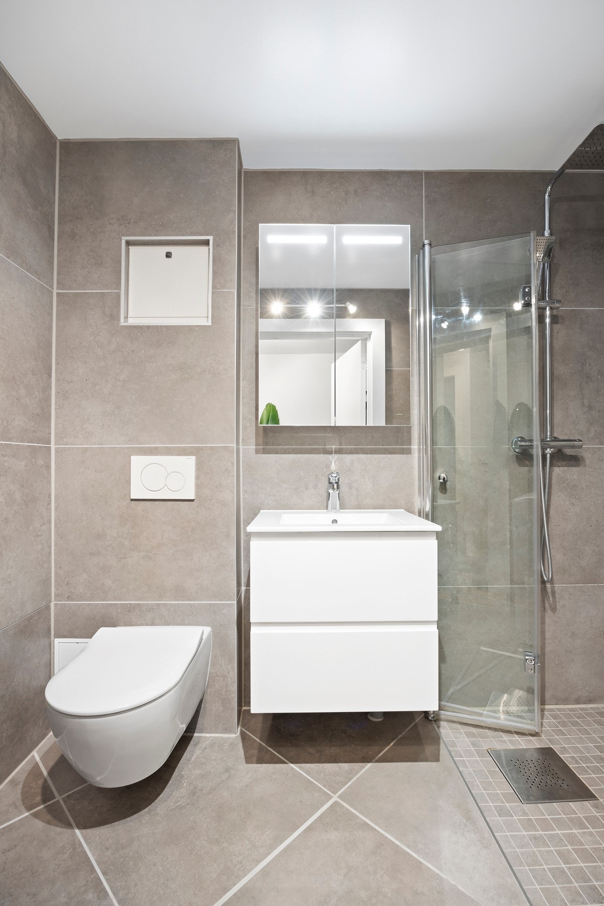 Baderommet har vegghengt wc fra Villeroy Bosch, veggskap med speilfronter og lys, servantskap med skuffer og dusjhjørne. Galleribilde