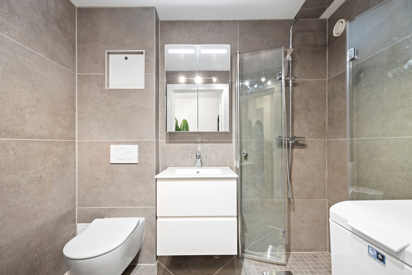 Pent og moderne baderom fra 2019 med lysegrå 60x60 fliser og mosikkfliser i dusjsonen. Gulvvarme. Galleribilde