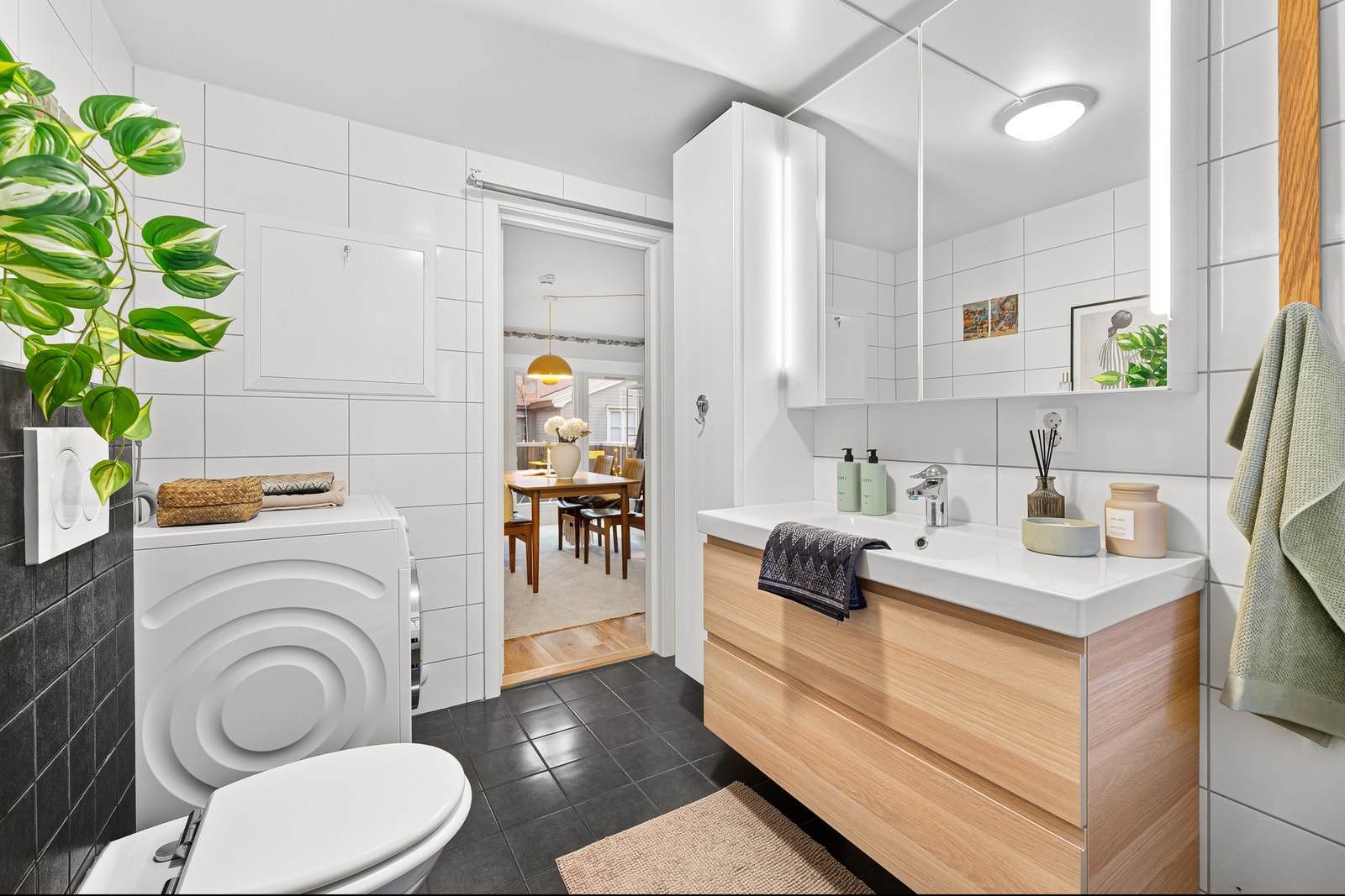 Flislagt bad fra 2018 med moderne innredning, vegghengt toalett og god plass til vaskemaskin. Galleribilde