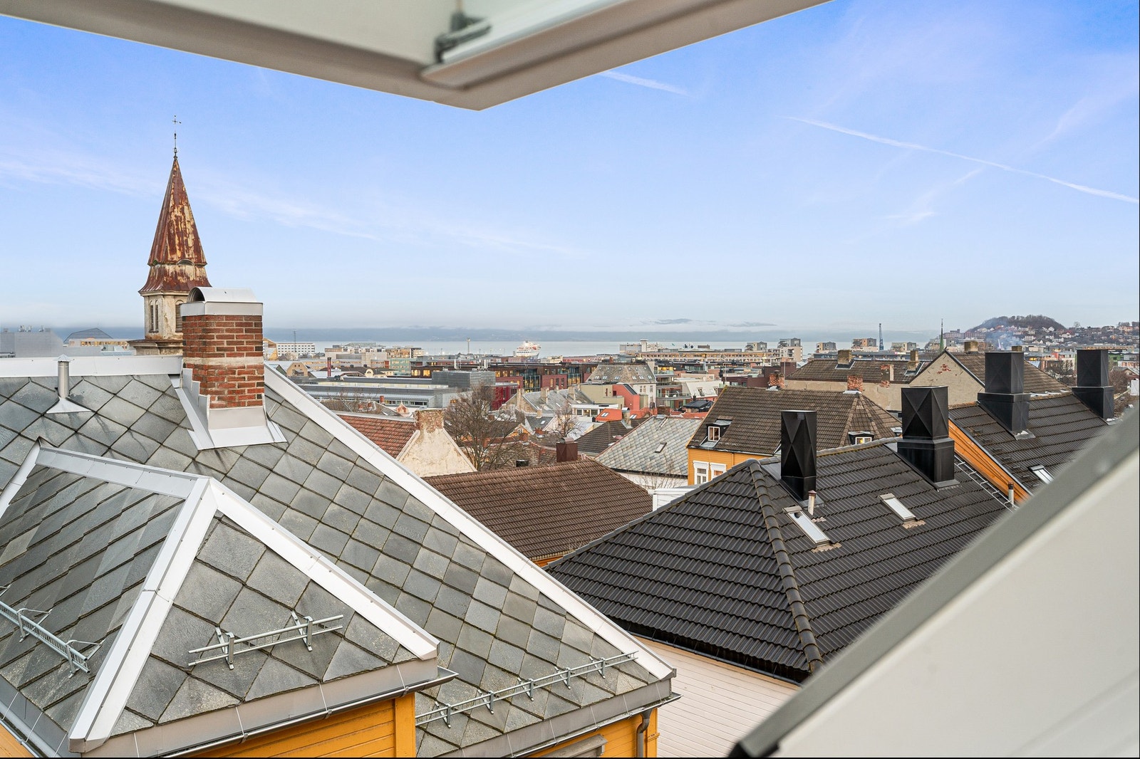 Flott utsikt over nærområdet og byens taklandskap, med glimt av fjorden. Galleribilde