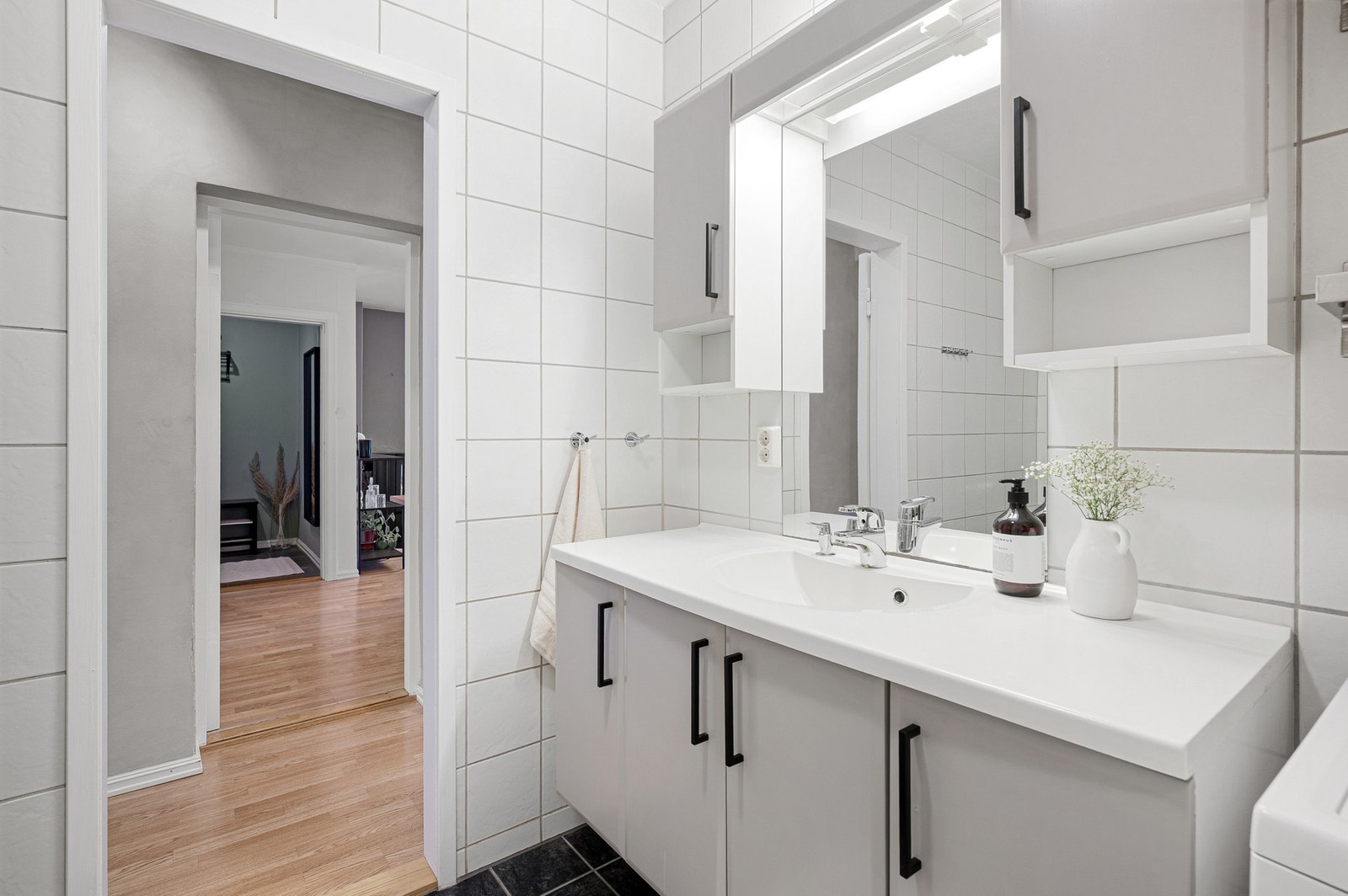 Baderommet består av vegghengt WC, kran og avløp for vaskemaskin, servantplate på underskap og speilskap. Galleribilde