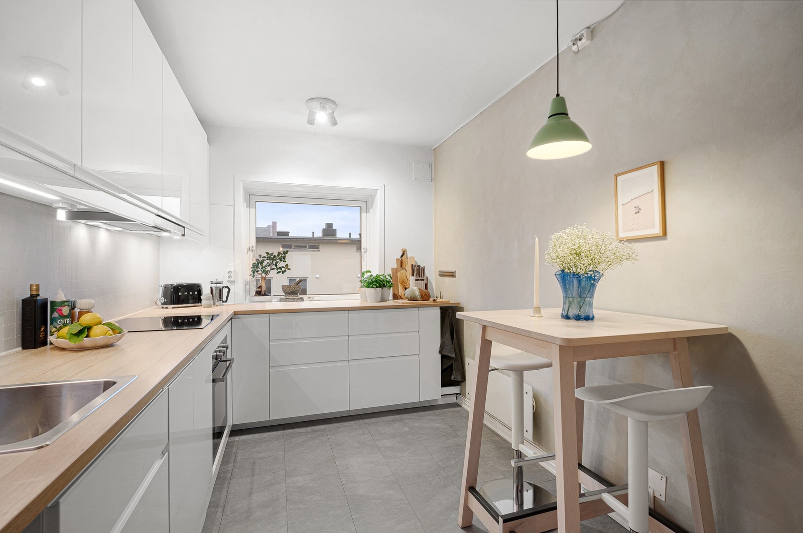 Stilrent kjøkken med plane fronter og laminerte benkeplater. Galleribilde