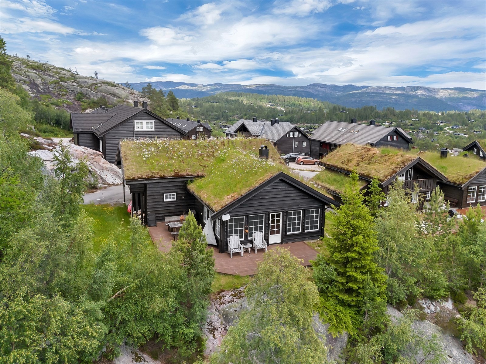 Hytta ligger trukket vekk fra veien i enden av feltet og ligger lunt inn mot heia bak. Galleribilde