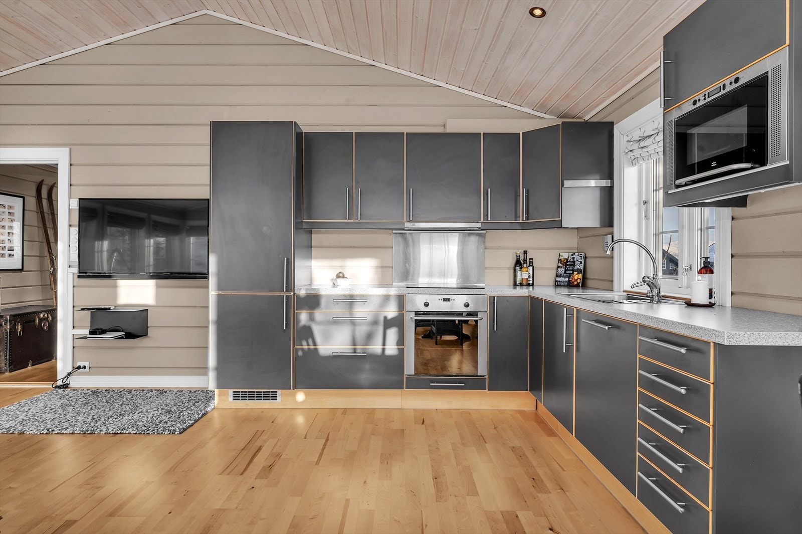 Grått kjøkken med glatte fronter, integrerte hvitevarer og masse plass i skuffer og skap. Galleribilde