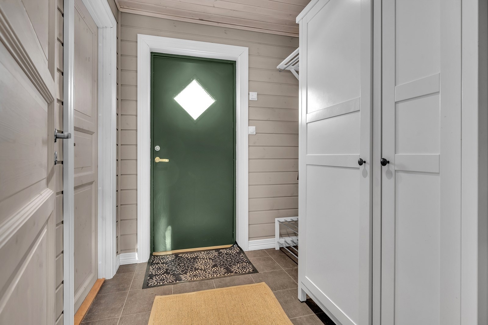 Flislagt vindfang med varmekabler. Plass til ytterklær og sko. Det er også adkomst via stor bod. Galleribilde