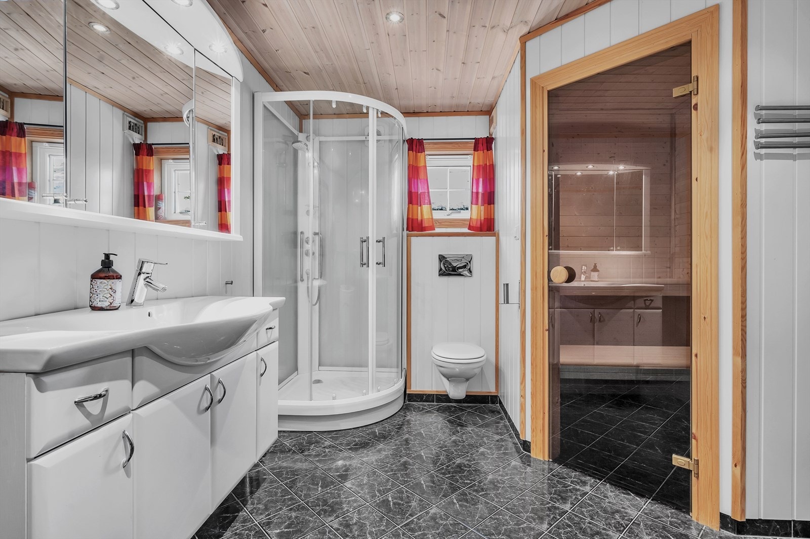 Stort flislagt bad i 1. etasje innredet med boblekar, dusjkabinett, toalett og servant med innredning. Adkomst til badstue fra badet. Galleribilde