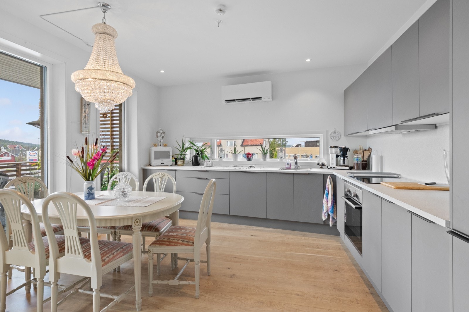 Innredningen har glatte, lysegrå fronter og hvit benkeplate av laminat med nedfelt oppvaskkum. Galleribilde