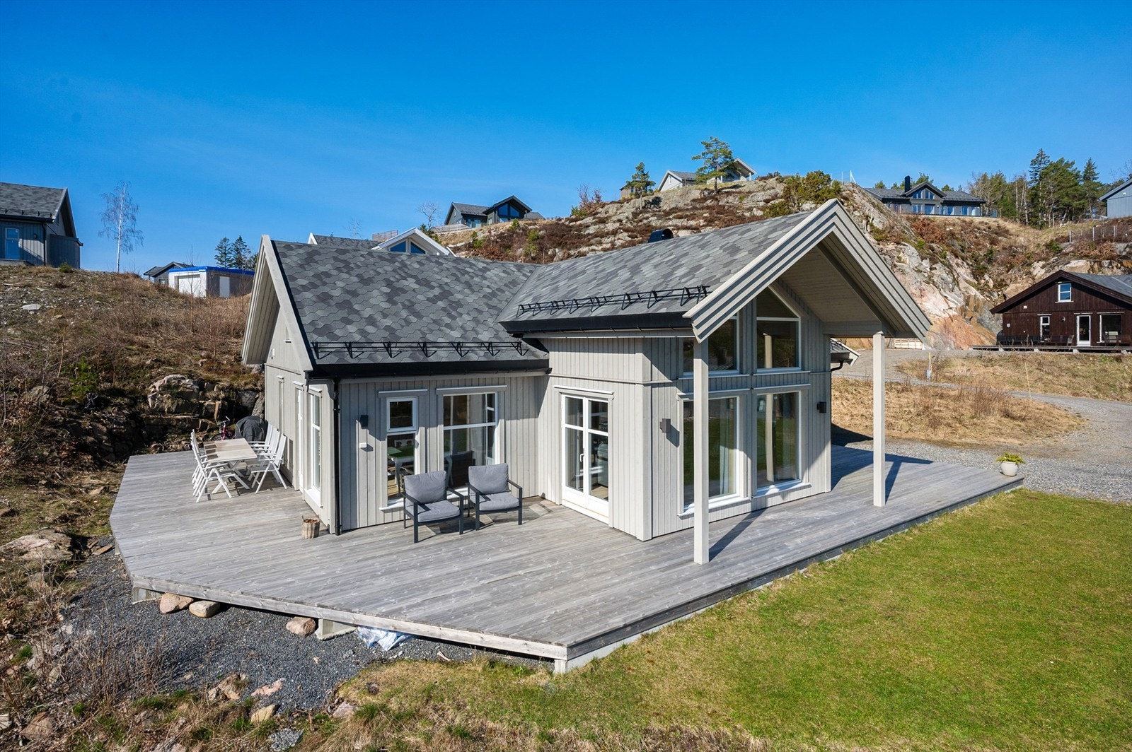 Eiendommen har en romslig tomt opparbeidet med plen, terrasse og gruset innkjørsel hvor det er gode parkeringsmuligheter Galleribilde