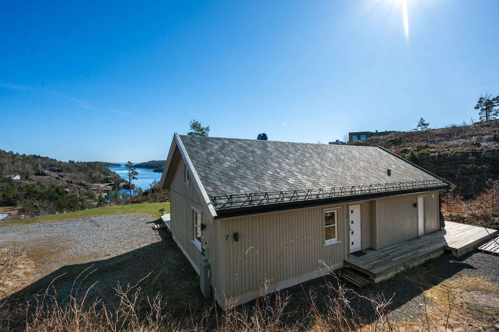 Inngangsparti på baksiden av hytten. Montert elbillader på vegg ved parkering. Galleribilde