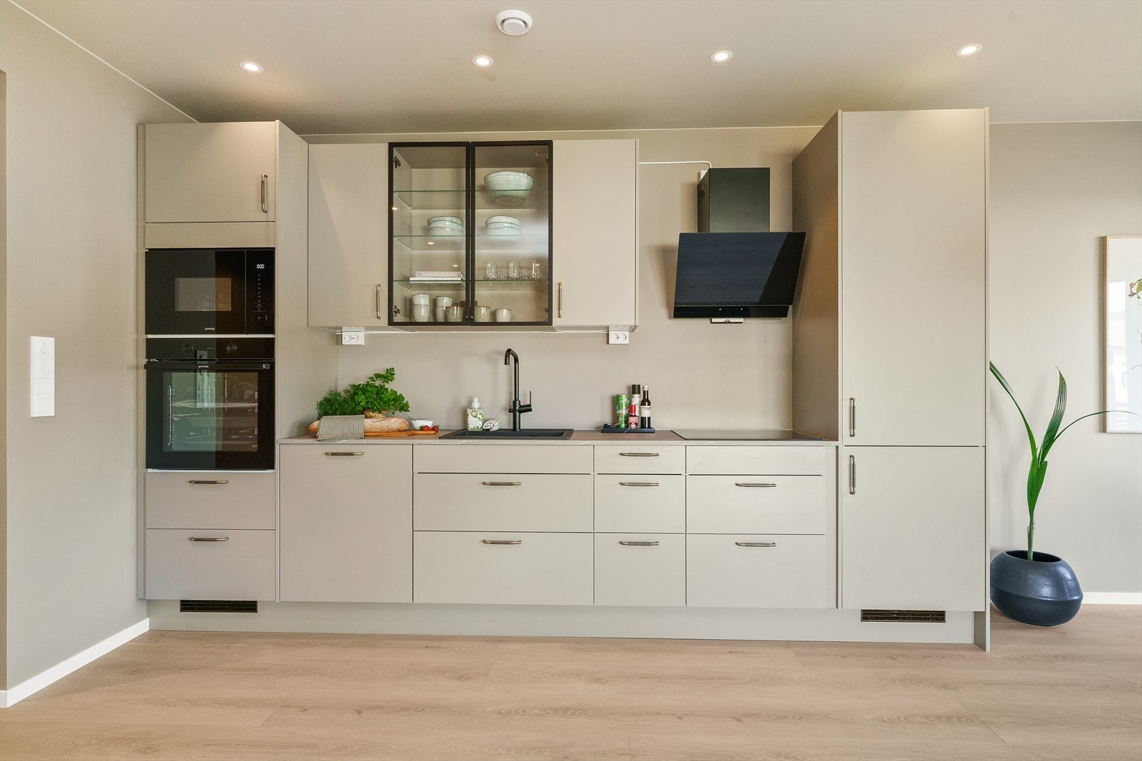 Moderne og elegant kjøkken med glatte fronter og laminert benkeplate. Kjøkkenet har integrerte hvitevarer. Galleribilde