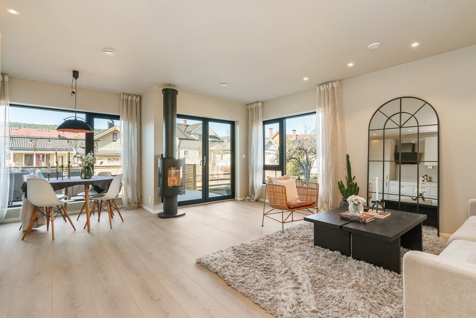 Boligen har store vindusflater som slipper inn rikelig med dagslys, samt utgang til boligens uteområde. Peis er sentralt plassert i rommet. Galleribilde