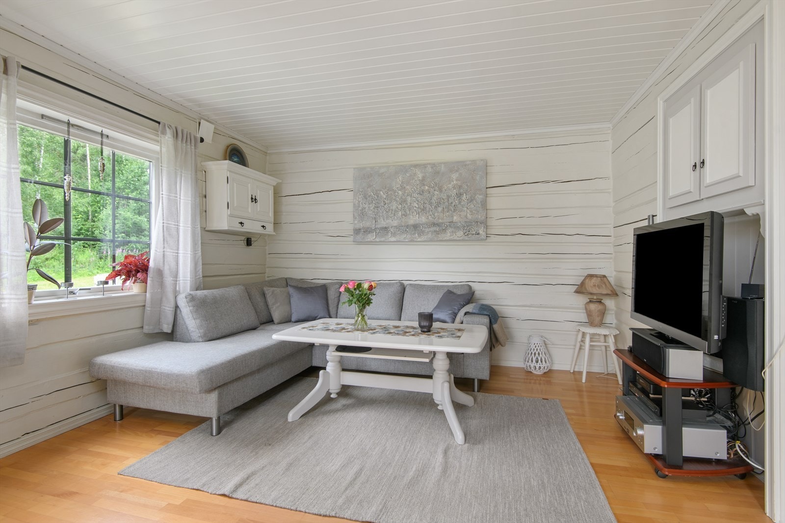 I stuen kommer tømmervegger fra opprinnelig bolig frem Galleribilde