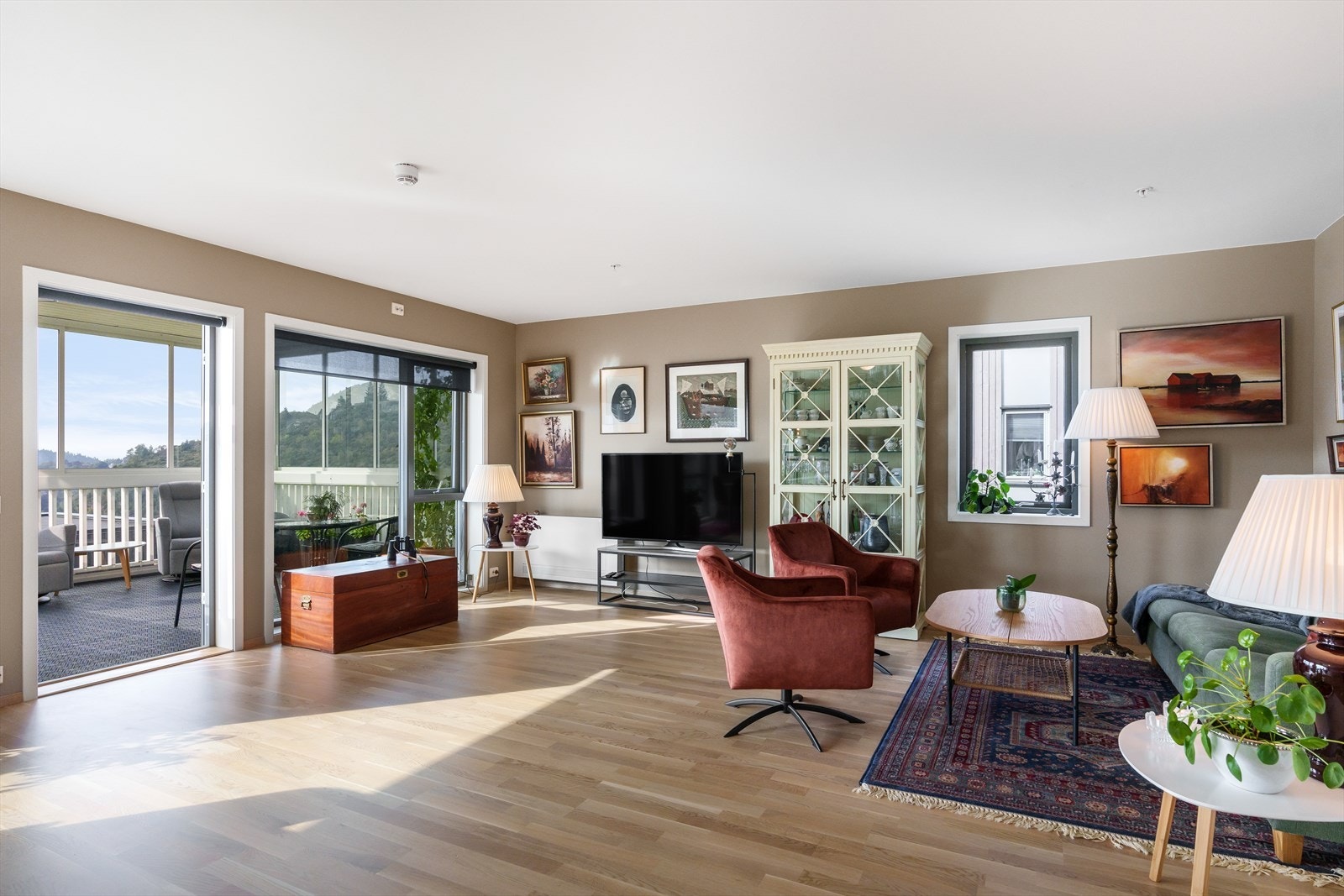 Stor og lys stue med utgang vestvendt innglasset terrasse Galleribilde