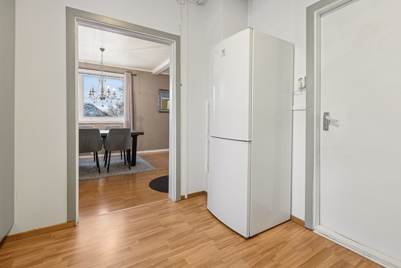 Boligen har en praktisk og sosial løsning med åpen forbindelse mellom kjøkken og spisestue. Dette gir en luftig og innbydende atmosfære, perfekt for hyggelige måltider og samvær med familie og venner. Galleribilde