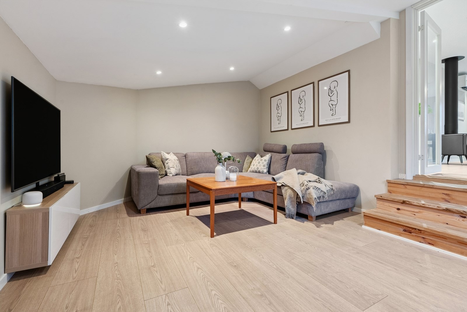 En praktisk og dekorativ tretrapp og dobbelfløyet dør binder sammen de to nivåene i stue og kjøkken Galleribilde