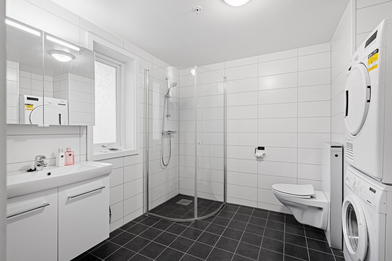 Baderommet er innredet med vegghengt toalett, dusjhjørne, servantseksjon og opplegg for vask/tørk. Inngang til praktisk bod/teknisk rom fra badet. Galleribilde