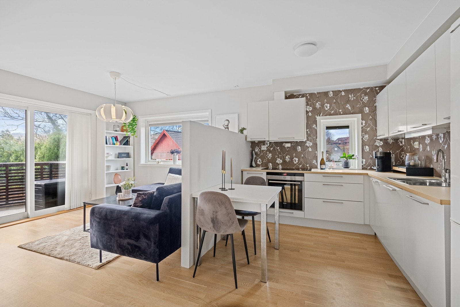 Kjøkkenet har hvite, slette fronter og integrert komfyr, koketopp og oppvaskmaskin. Galleribilde