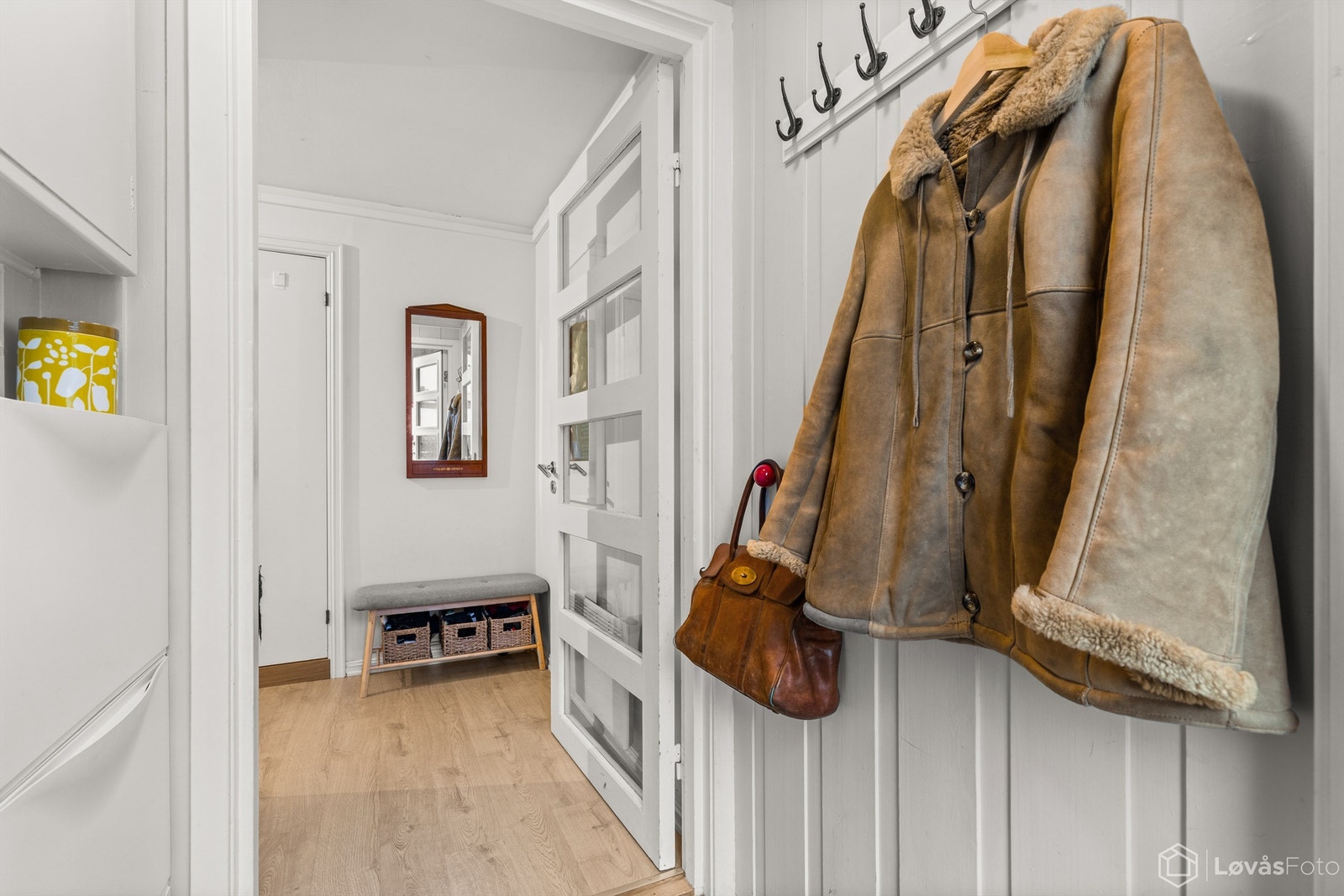 En innerdør med glassfelt mellom entré og gang slipper lyset videre inn i leiligheten. Galleribilde