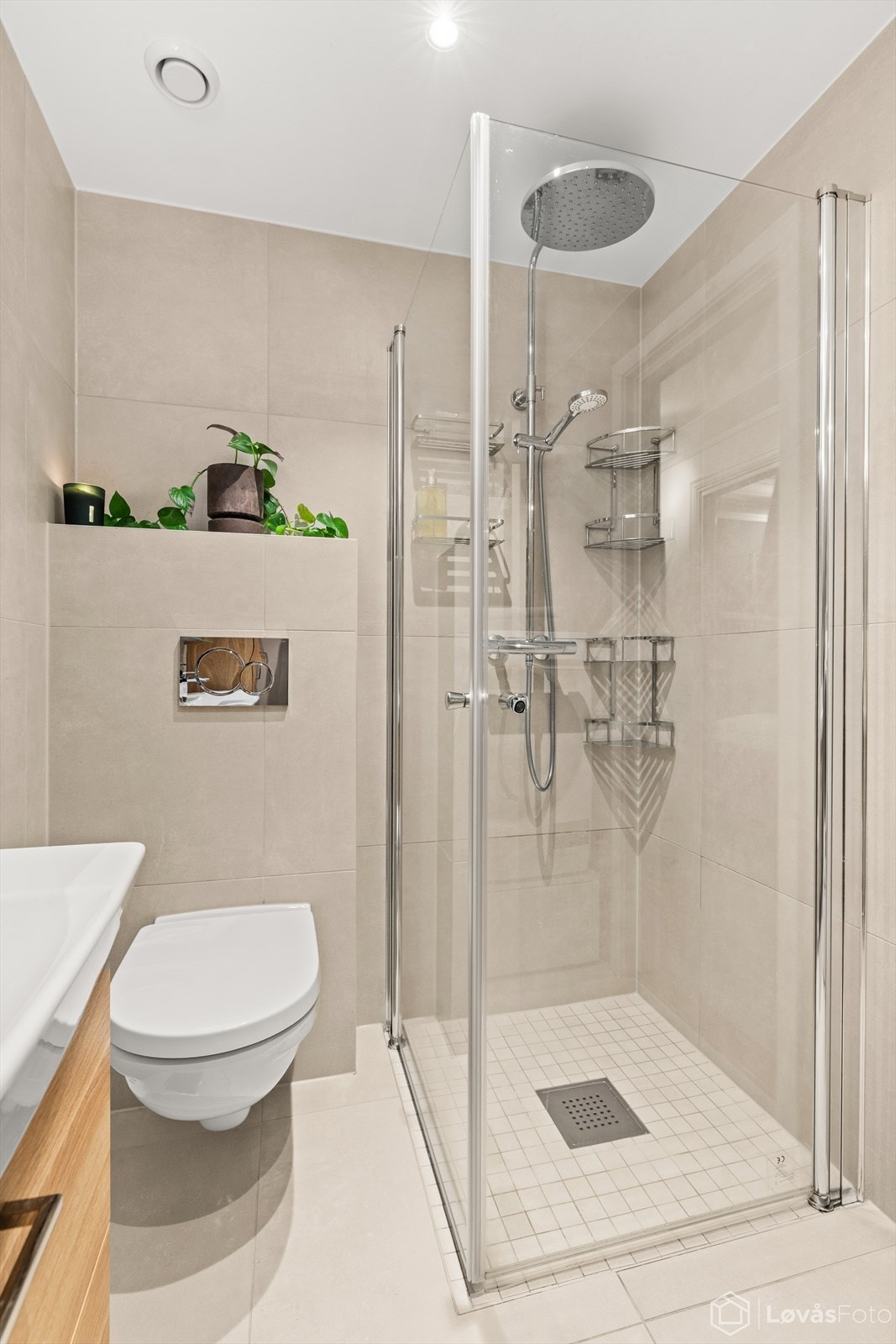 Her er det vegghengt toalett fra Geberit og en dusjnisje med glassdører. Galleribilde