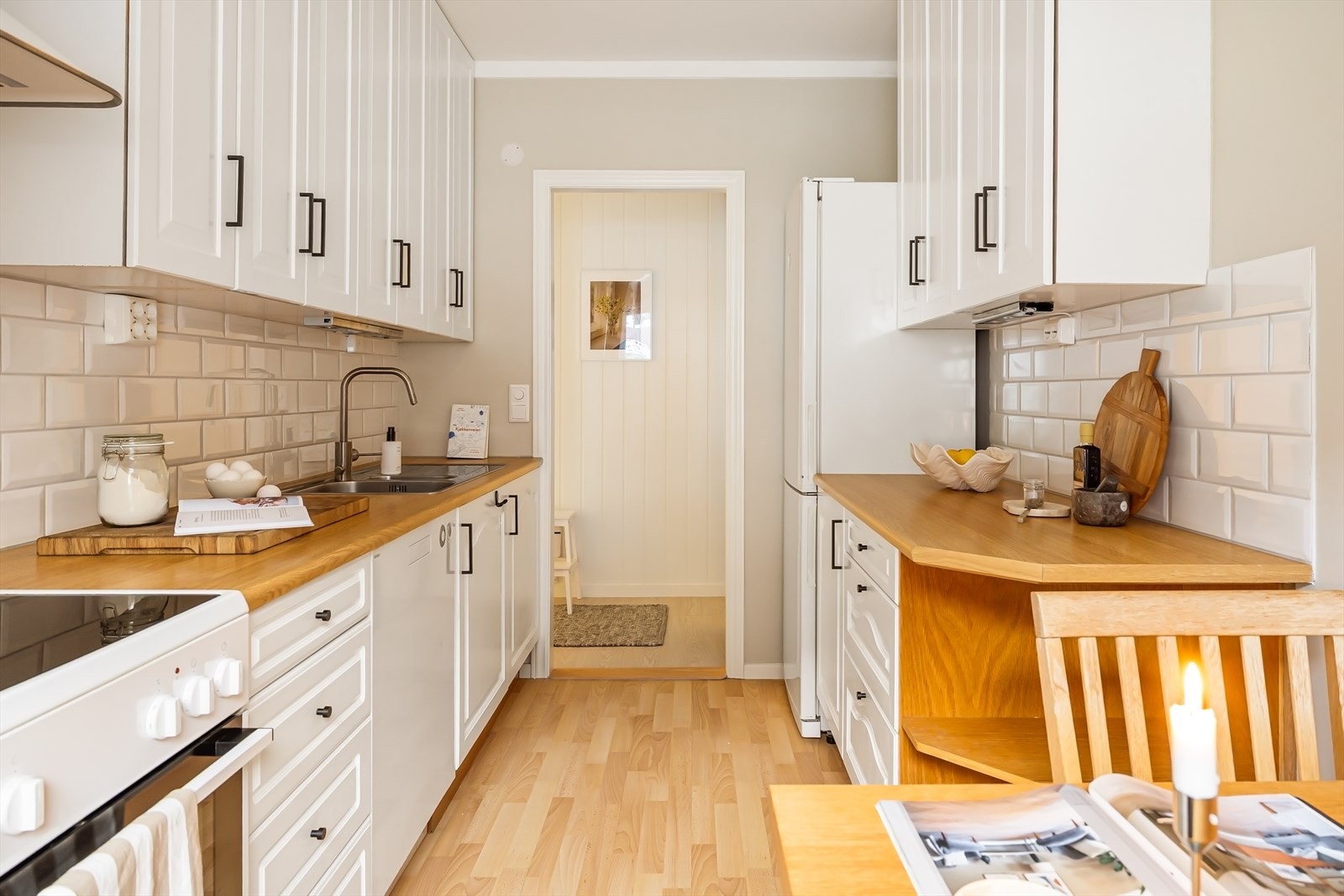 Innholdsrikt kjøkken med hvite profilerte fronter og benkeplate i laminat. Alle hvitevarer på kjøkkenet medfølger. Galleribilde