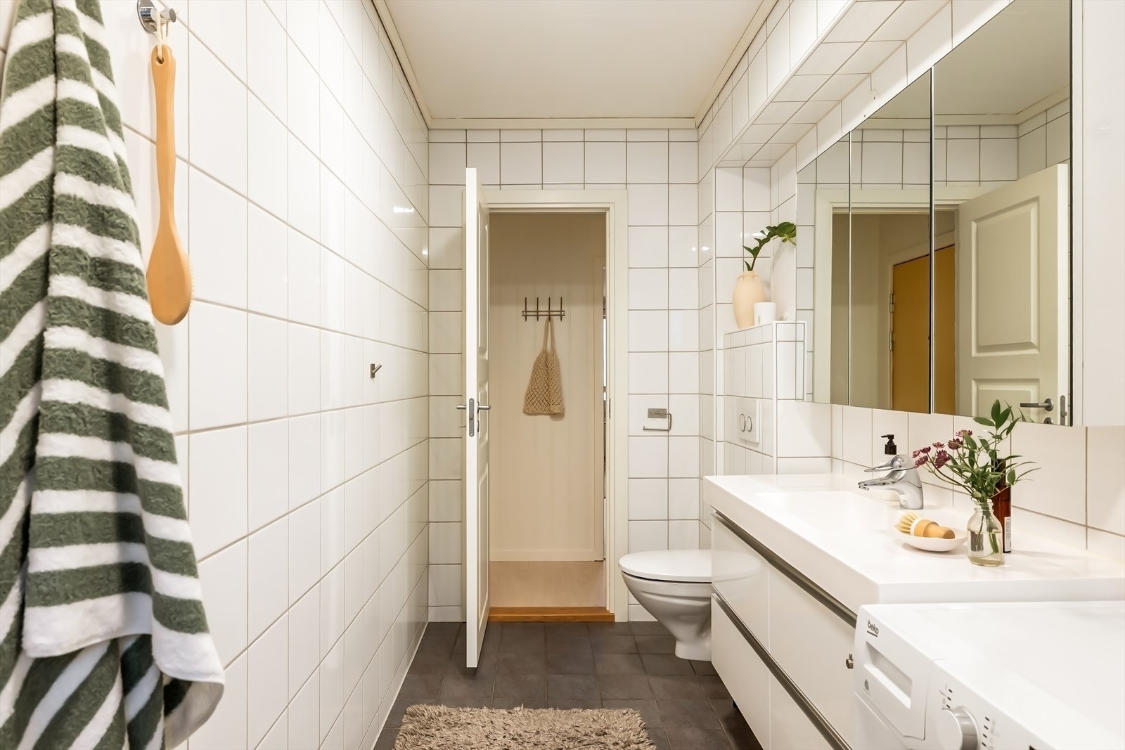 Helfliset bad med varmekabler i gulv, vegghengt wc, dusjsone og opplegg for vaskemaskin. Galleribilde