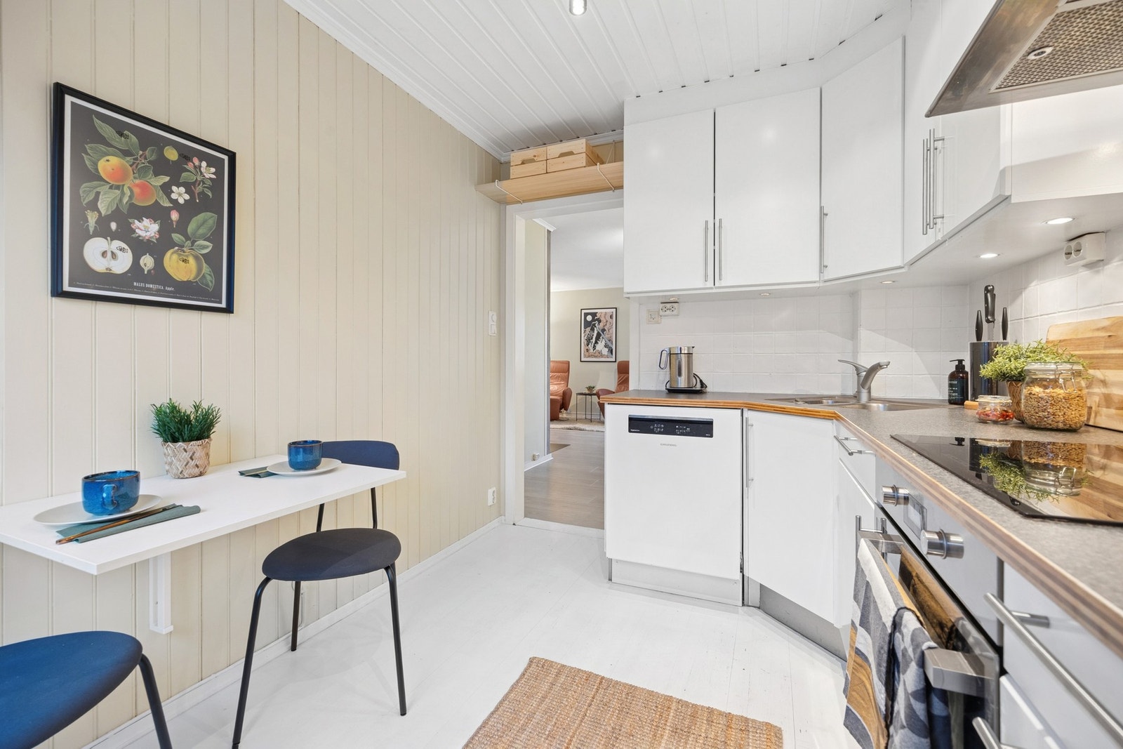 Den adskilte plasseringen av kjøkkenet skaper en fin avskjerming fra stuen og gir rommet en egen sone, samtidig som det er plass til et lite kjøkkenbord. Galleribilde