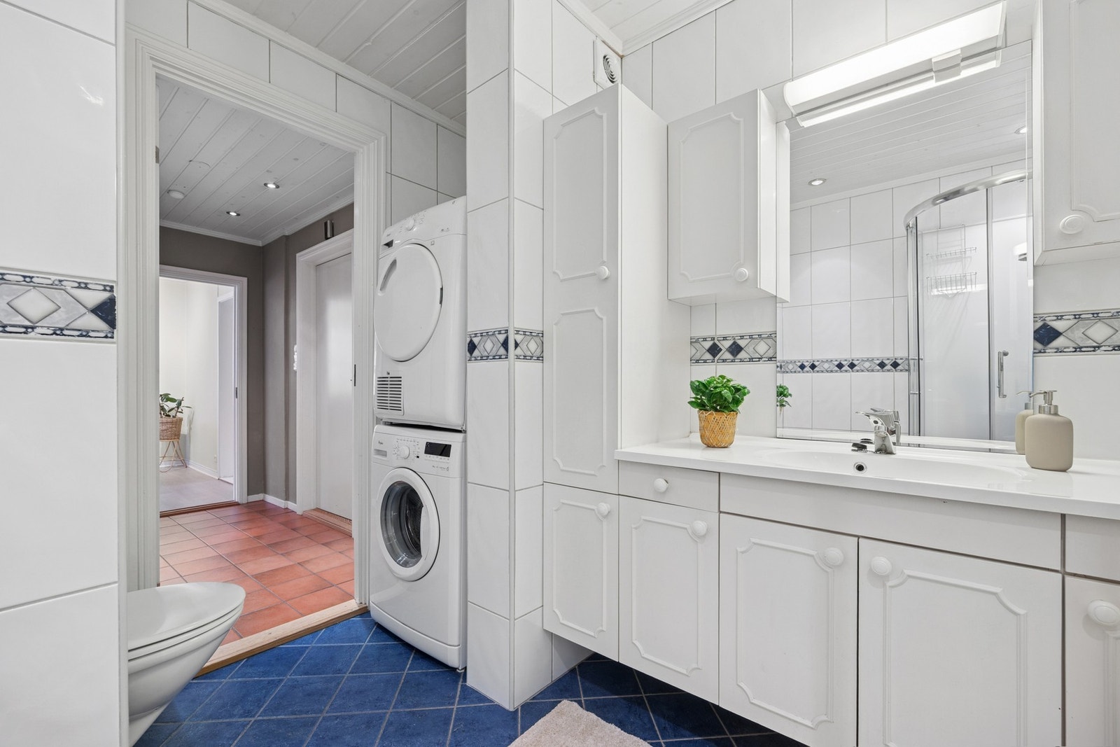 Det romslige badet på ca. 5,5 m² er flislagt og velholdt, med behagelig gulvvarme og plass til både vaskemaskin og tørketrommel. Galleribilde