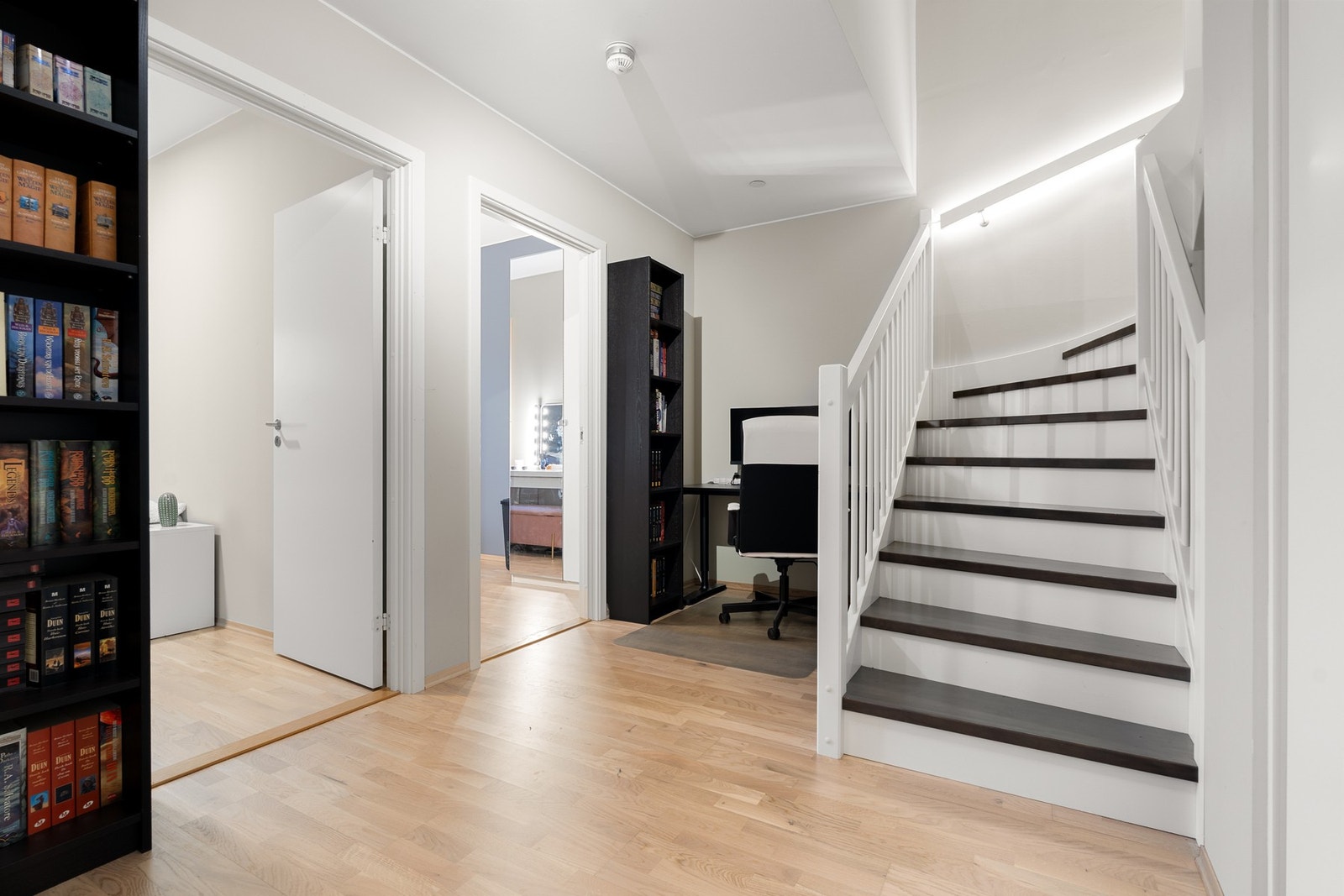 I boligens sokkeletasje finner vi tre gode soverom, bad og en romslig gang som byr på fleksible bruksmuligheter. Gangen er i dag innredet med garderobeskap og hjemmekontor. Galleribilde