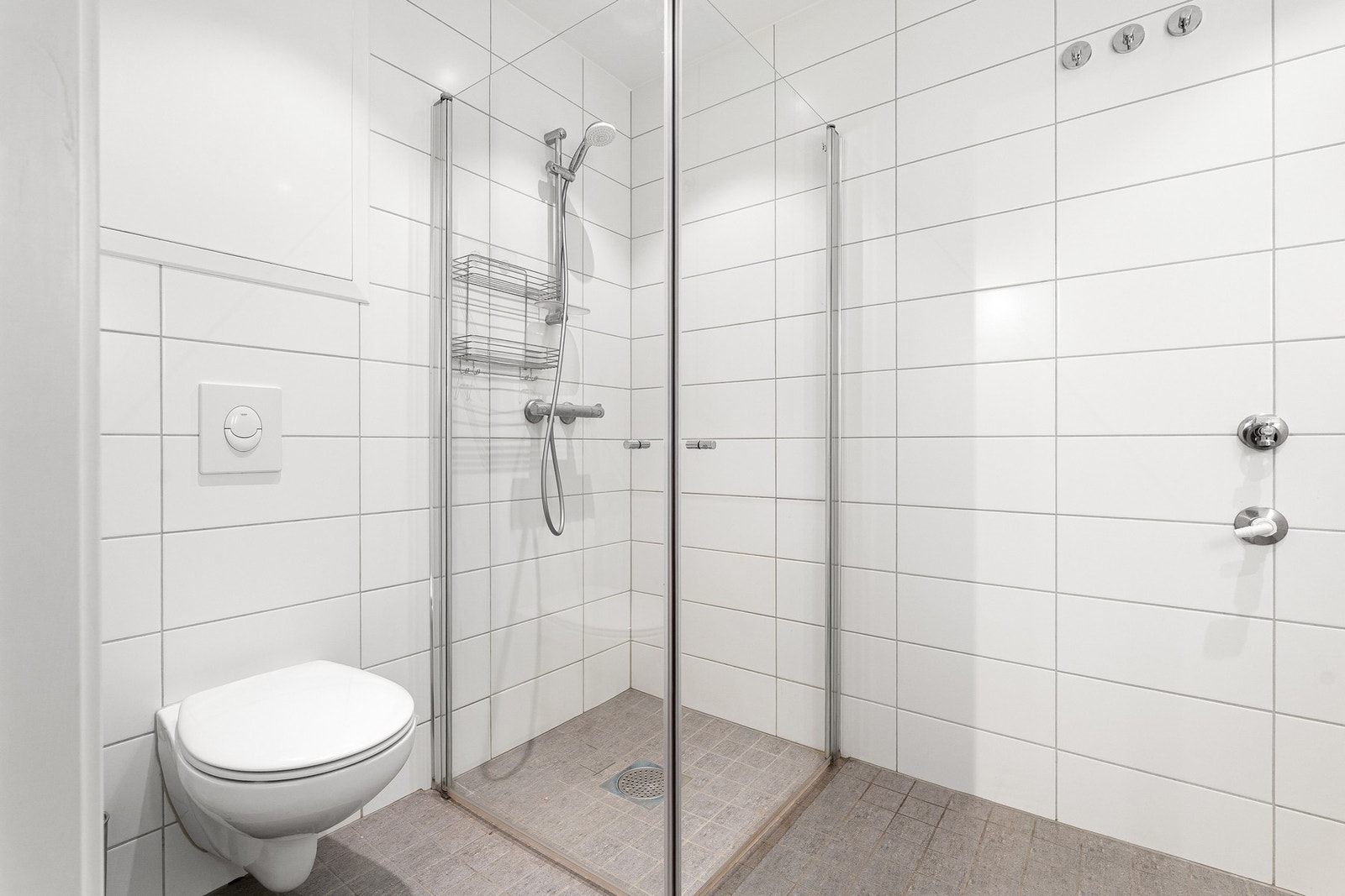 Baderommet er utstyrt med det nødvendige: dusjhjørne, servant i skap og veggmontert toalett. Galleribilde