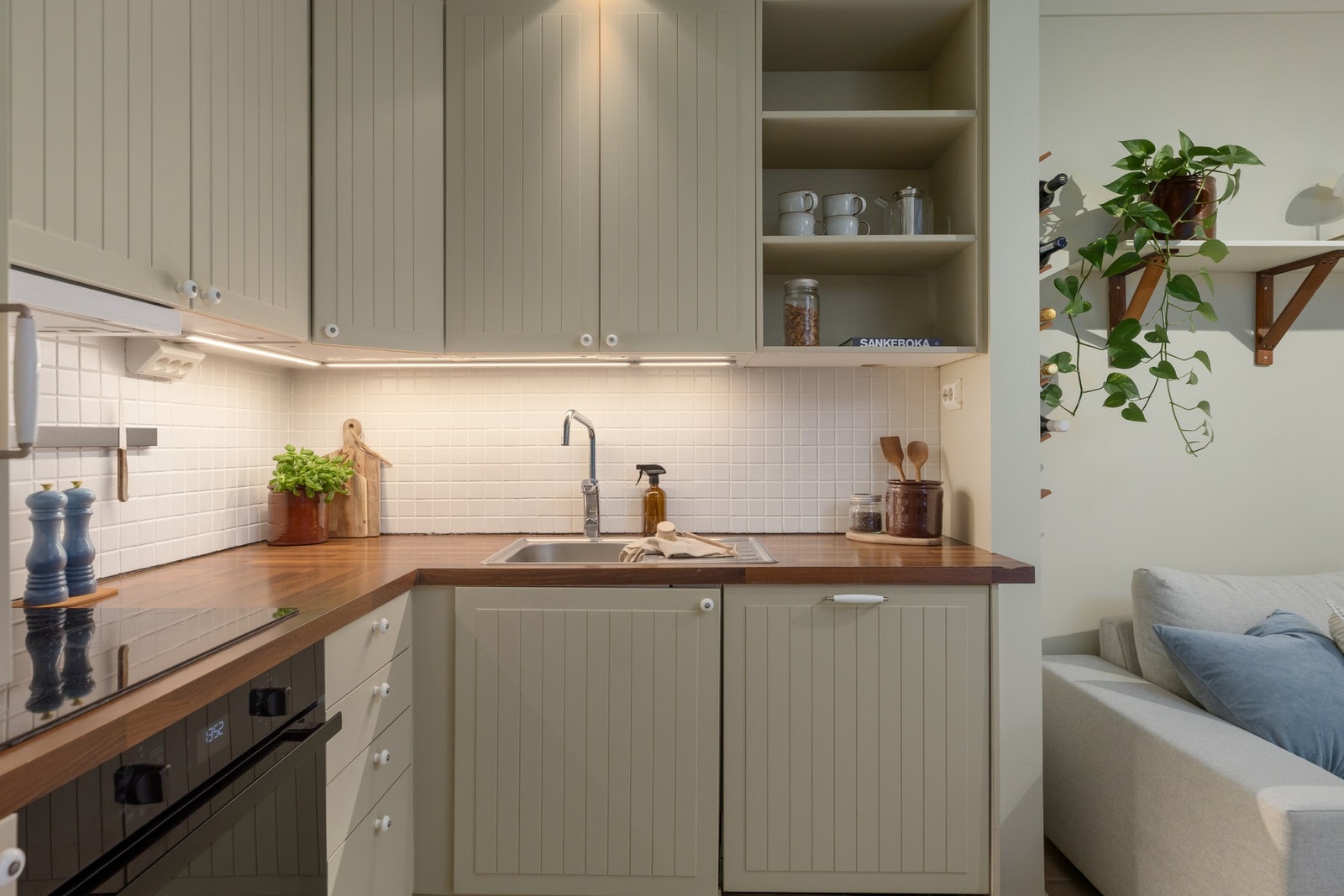 Det er laminat benkeplate og fliser mellom over- og underskap. Galleribilde