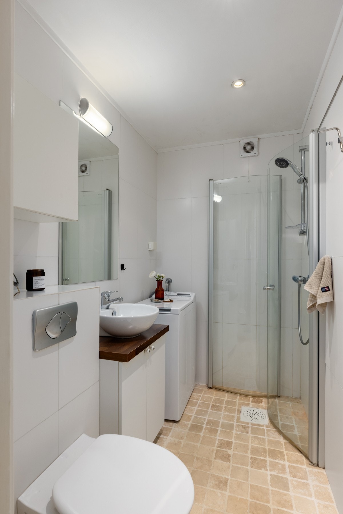 Badet er pent og tidløst fra 2006, med varmekabler i gulv, lyse fliser på vegger og gulv, downlights i himling og opplegg for vaskemaskin. Galleribilde