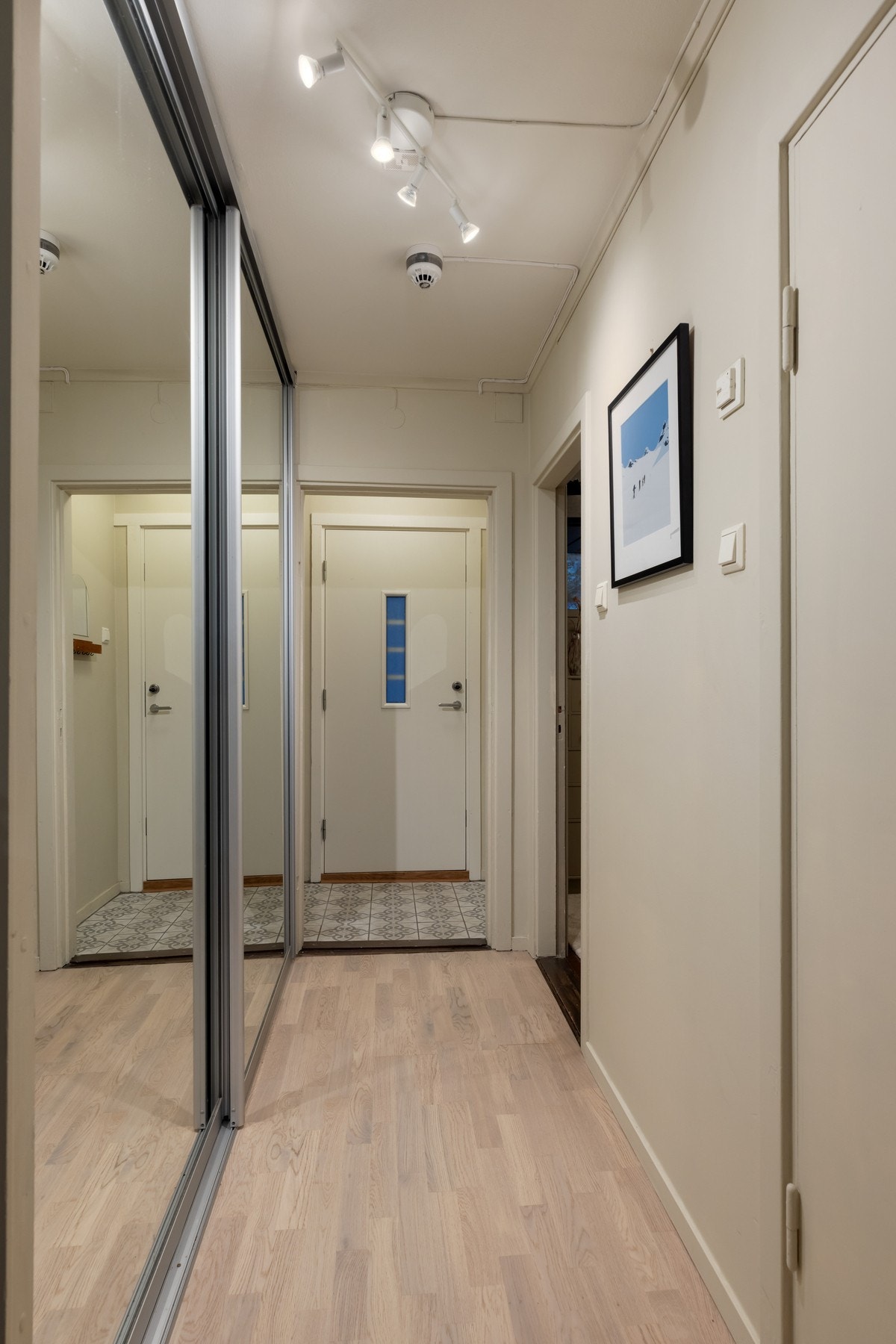 Entré og gang fremstår lyse og innbydende med fliser i entré og parkett i gang. Her er det også skyvedørsgarderobe. Galleribilde