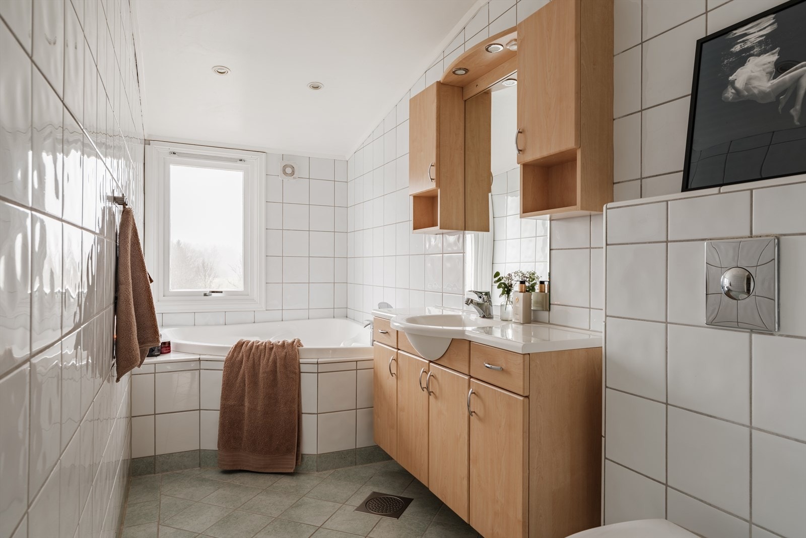 Baderommet i 2. etasje har flislagte gulv- og veggflater og er innredet med servantskap med nedfelt servant, veggskap med speildører og belysning, samt vegghengt toalett med innebygd sisterne. Galleribilde