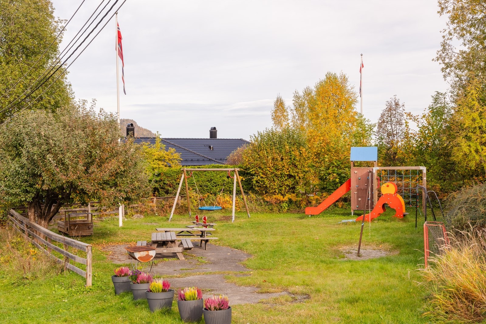 De minste kan leke på lekeplassen på andre siden av gjerdet, mens ungdommene samles i kjellerstuen for filmkvelder, og de voksne lager mat og er sammen rundt utekjøkkenet. Galleribilde