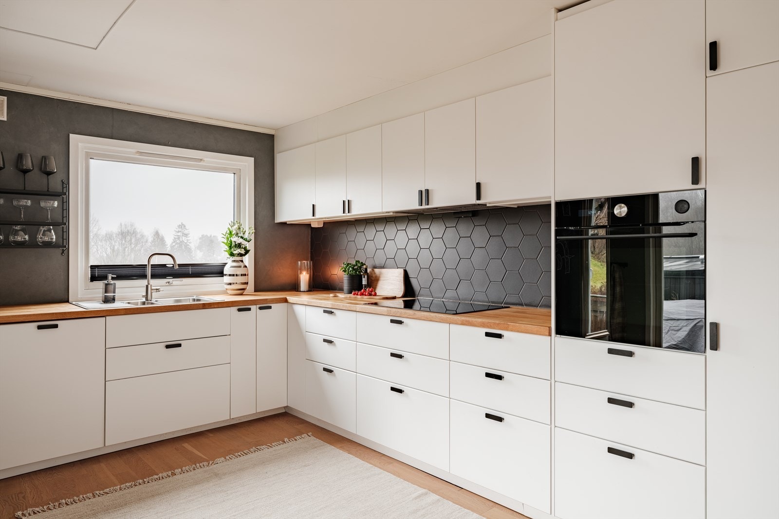 Det er fliser mellom benkeplate og overskap. Galleribilde