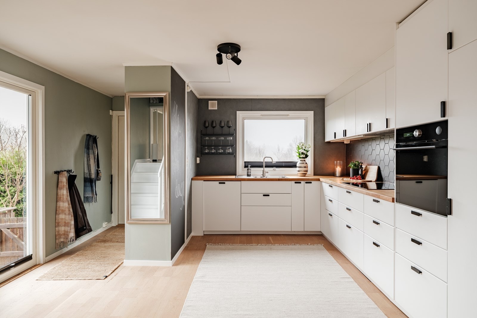 Kjøkkenet har et moderne og stilrent uttrykk med hvite, glatte fronter og helhetlig innredning fra 2018. Galleribilde