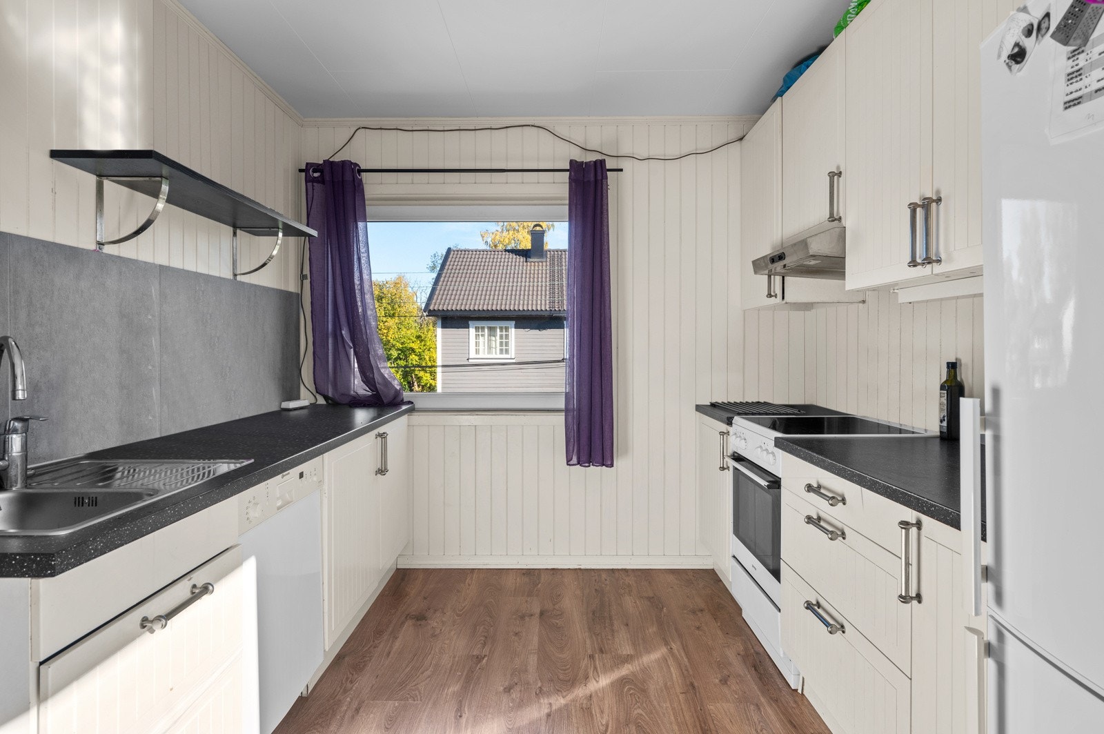 Kjøkkenet har innredning med glatte fronter. Benkeplaten er av laminat. Galleribilde