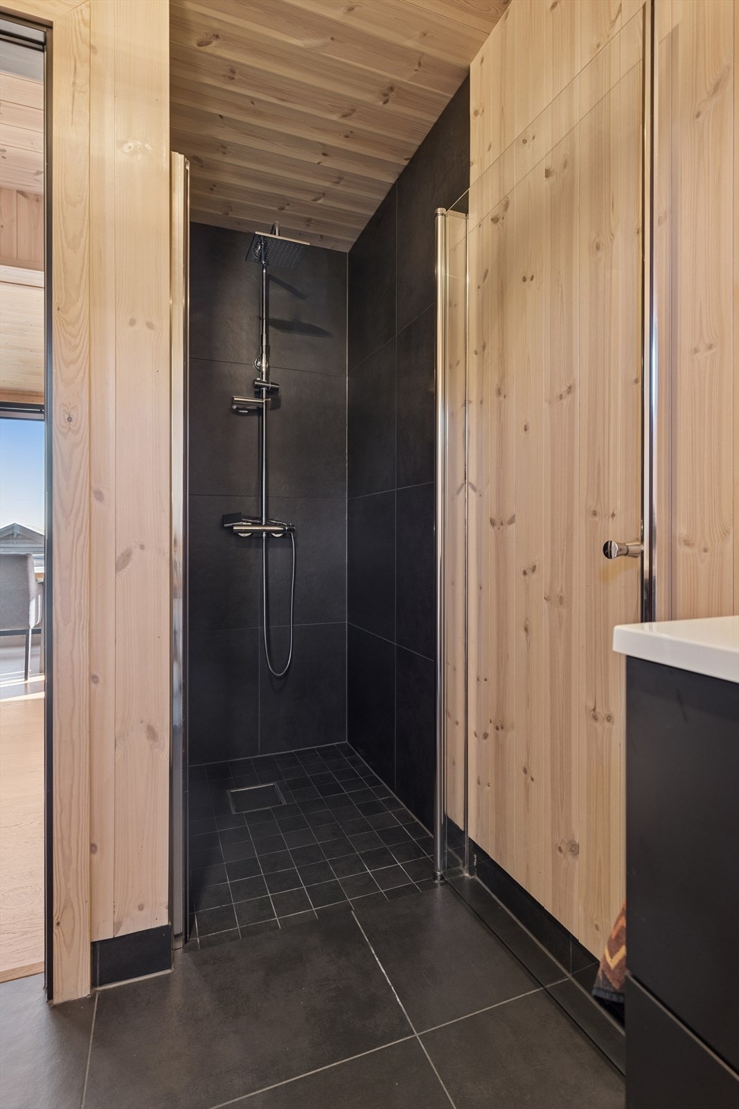 Her er det en lekker dusjnisje, en pen servantinnredning, speil, toalett og behagelig gulvvarme. Galleribilde