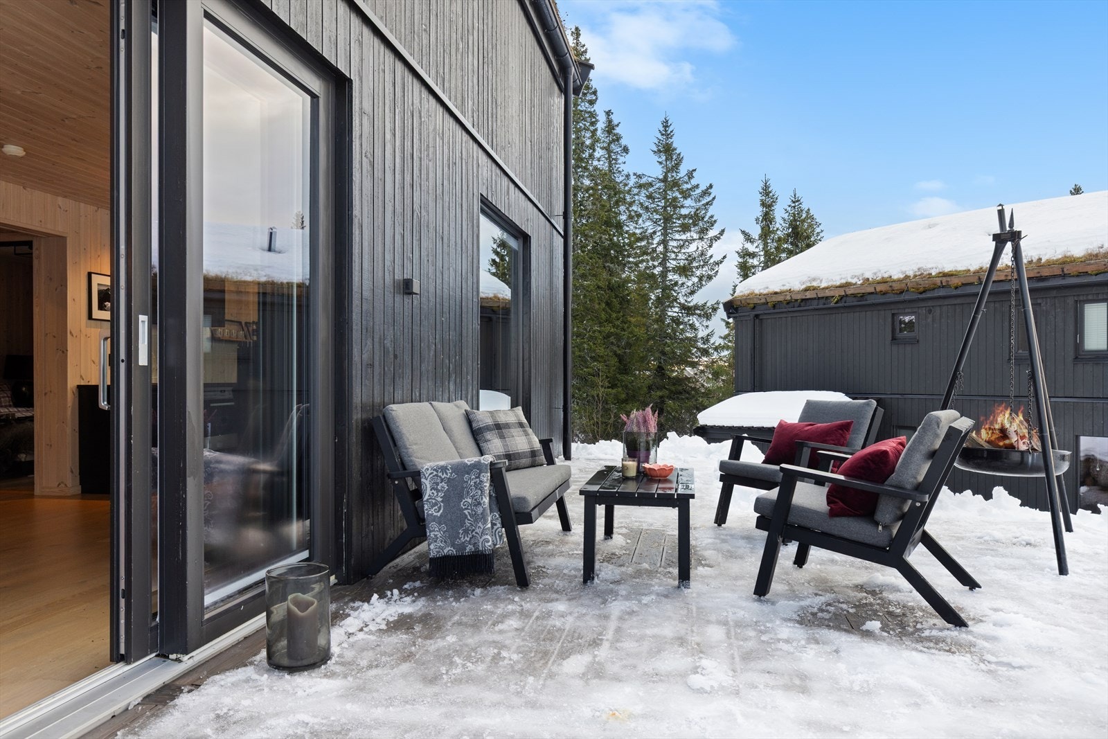 Stemningsfull uteplass med bålpanne og komfortable sitteplasser - perfekt for vinterkos Galleribilde