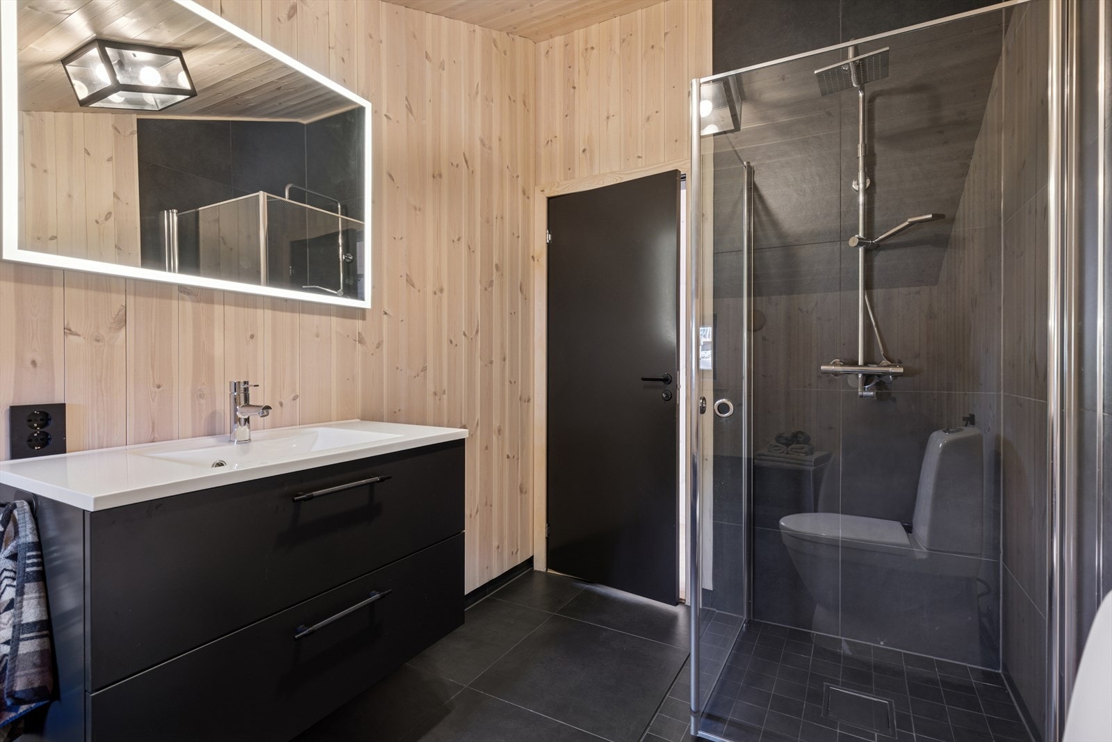 Badet er utstyrt med dusjhjørne, en moderne servantinnredning, speil og toalett. Baderomsinnredningene er av god kvalitet fra Strai. Galleribilde