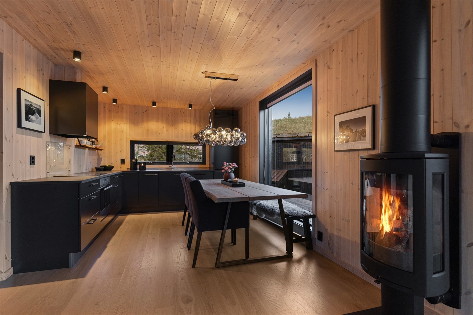 Mellom stuen og kjøkkenet er det en lekker vedovn som både er et dekorativt element, men som også bidrar med god varme gjennom vinteren. Galleribilde