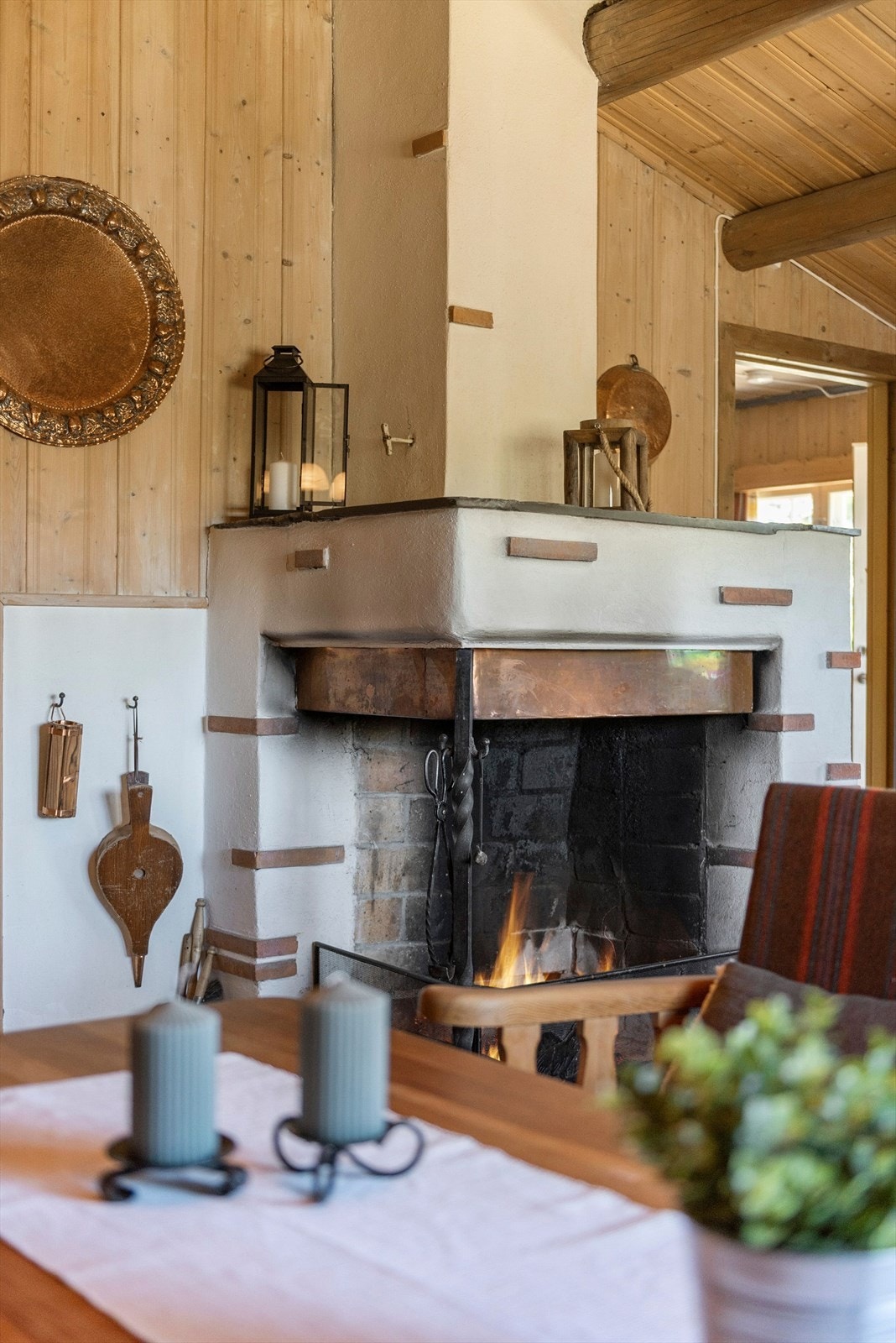 Koselig stue med plass til flere sittegrupper og med en åpen peis som et naturlig midtpunkt Galleribilde