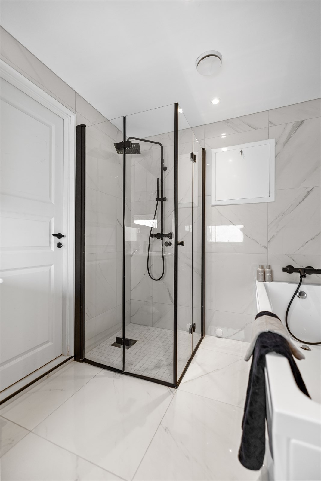 Rommet er innredet med badekar for avslappende stunder, samt et dusjhjørne med elegante glassvegger. Videre er det servantskap med god oppbevaringsplass, speilskap med integrert belysning og et vegghengt klosett. Galleribilde