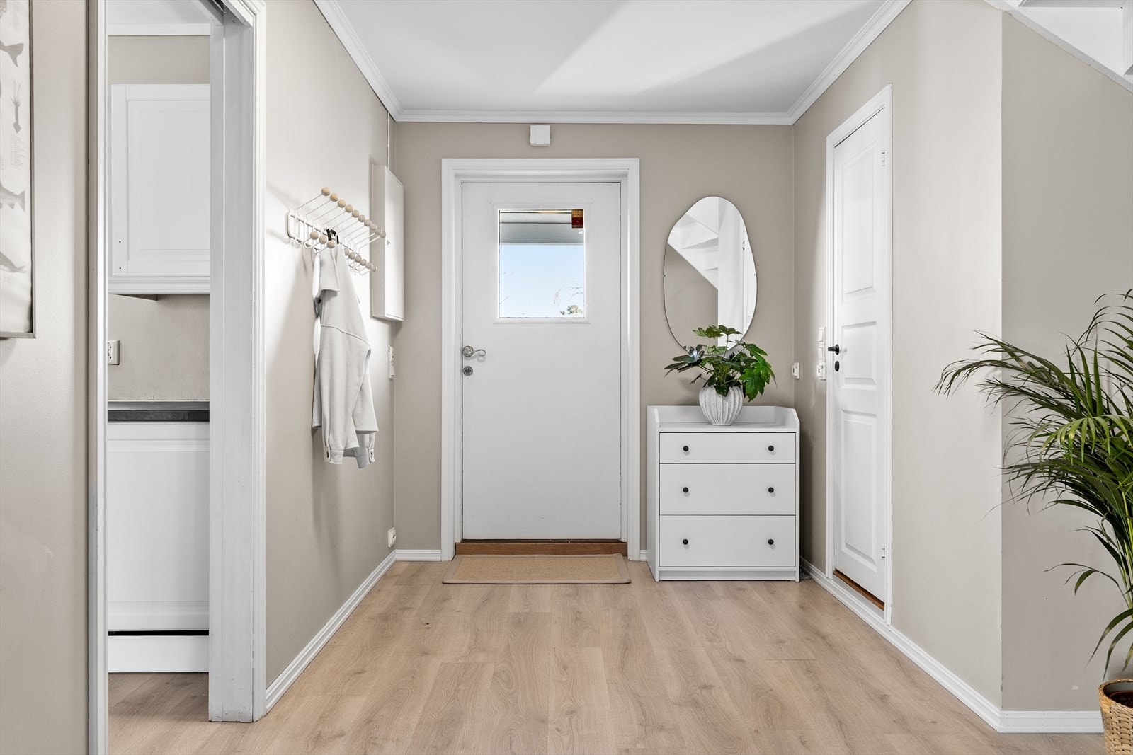 Allerede ved første steg inn får du en smak av boligens gjennomførte stil. Entréen fremstår lys, romslig og innbydende - med vegger malt i en vakker, varm beige tone som setter en elegant og harmonisk stemning for resten av hjemmet. Galleribilde