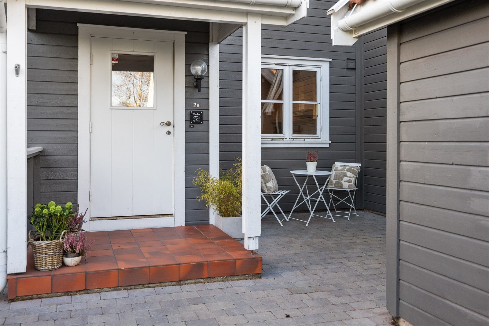 Hyggelig og velstelt inngangsparti med belegningsstein som gir et elegant og ryddig uttrykk. Her er det god plass til både pynt, blomsterkrukker og sesongdekor - et varmt førsteinntrykk som setter tonen for resten av boligen. Galleribilde