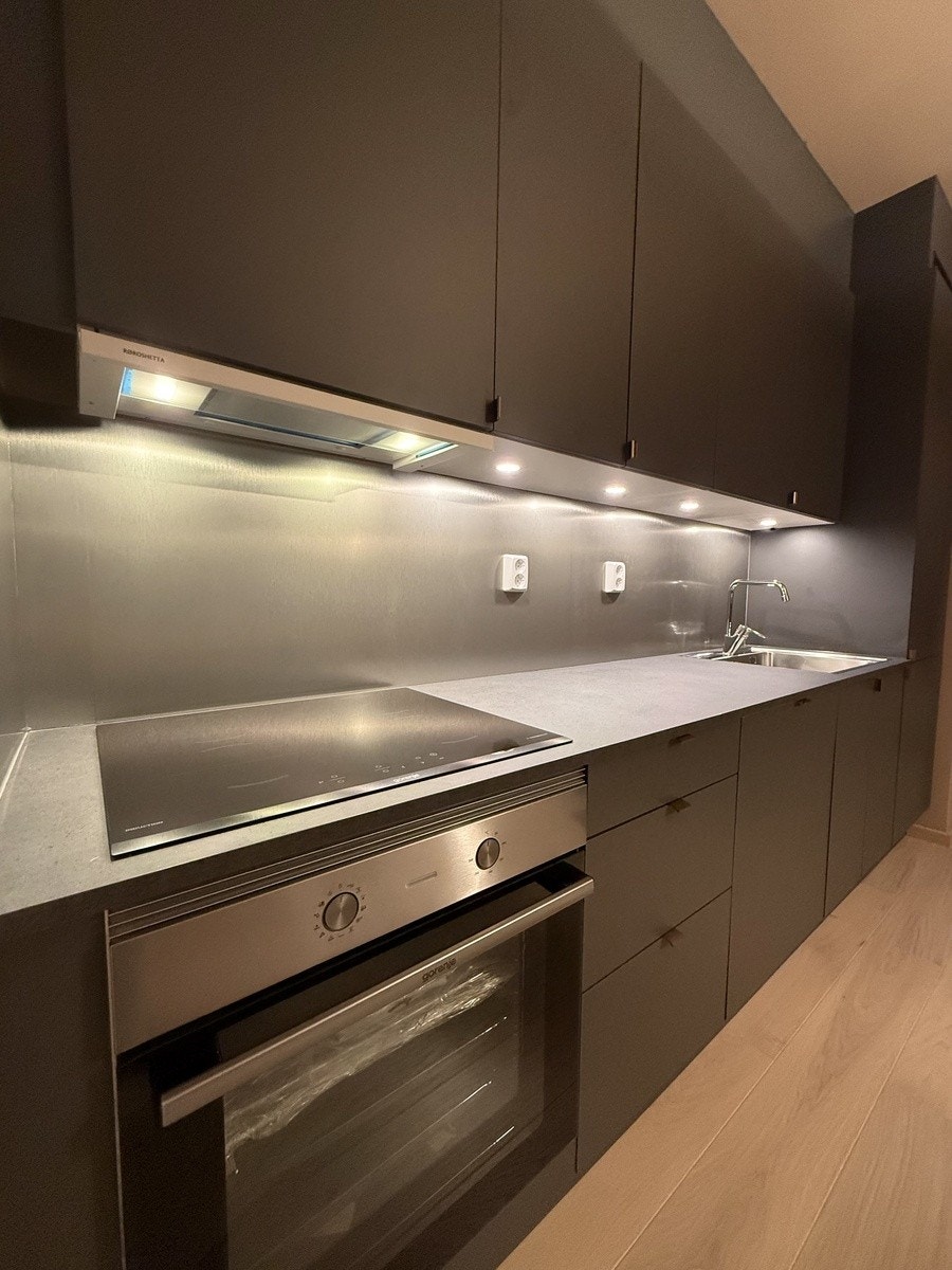 Moderne uttrykk og praktisk belysning under overskapene Galleribilde